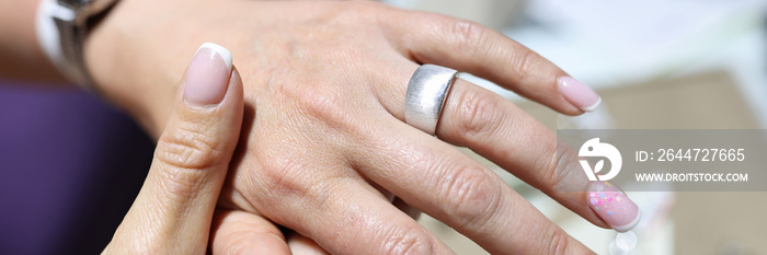 Woman tries on wide silver ring on her finger