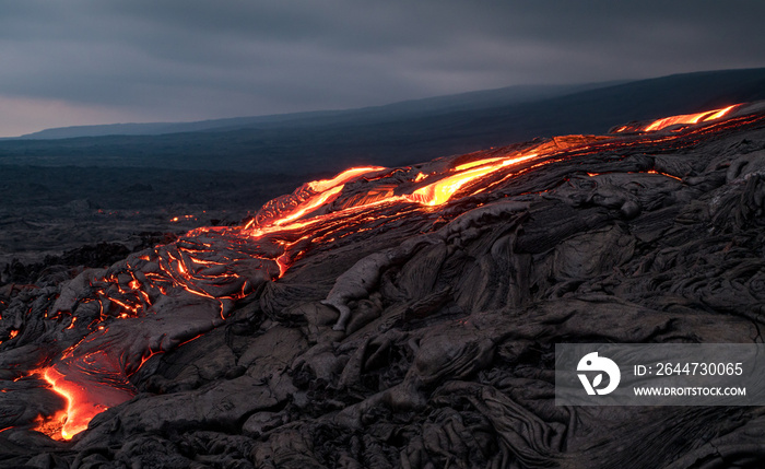 Closeup of glowing lava flow from Puu Oo in the evening on the Pali in Kalapana, Big Island, Hawaii.