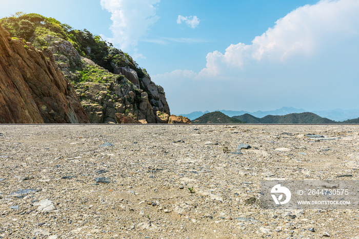 Gravel road and mountain landscape by the sea.