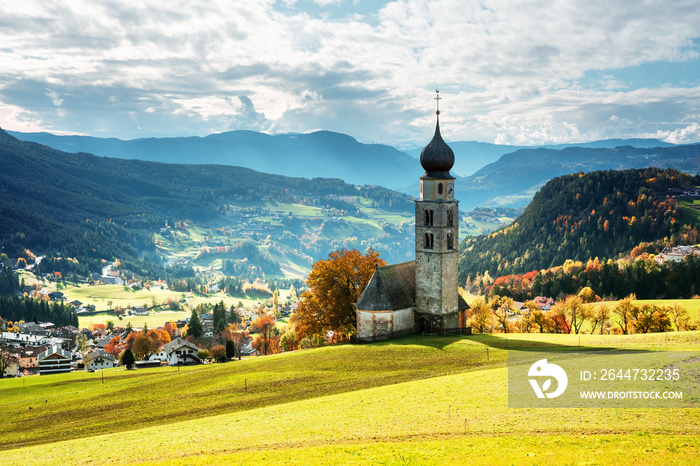 St. Valentin (Kastelruth) Village Church at the autumn Dolomite Alps. Amazing landscape with small chapel on sunny meadow and snowy Petz peak at Kastelruth commune. Dolomites, South Tyrol, Italy