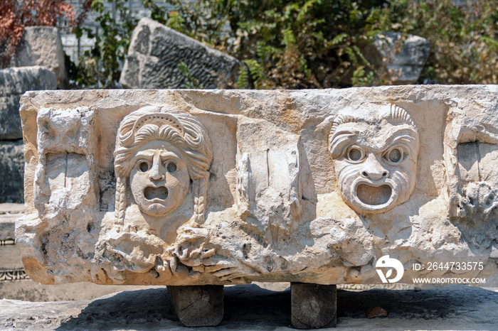 Fragment of marble decoration with tragedy mask bas-relief. Ruined ancient theater in Myra, old antique city (Turkey). Close up fragment. History, art or architecture concept