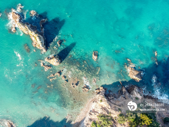 Stunning wide angle aerial drone view of rocks in the water at Otama Beach near Matarangi on the Coromandel Peninsula in New Zealand. Beautiful pattern / texture of ocean and beach.