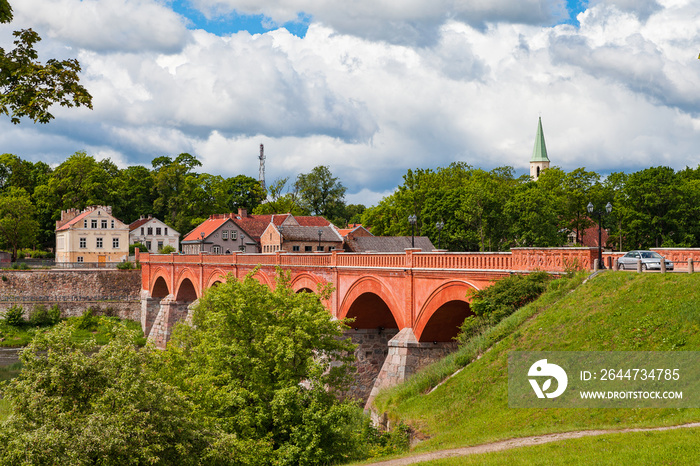 Old brick bridge over Venta river in Kuldiga, Latvia. Summer time.