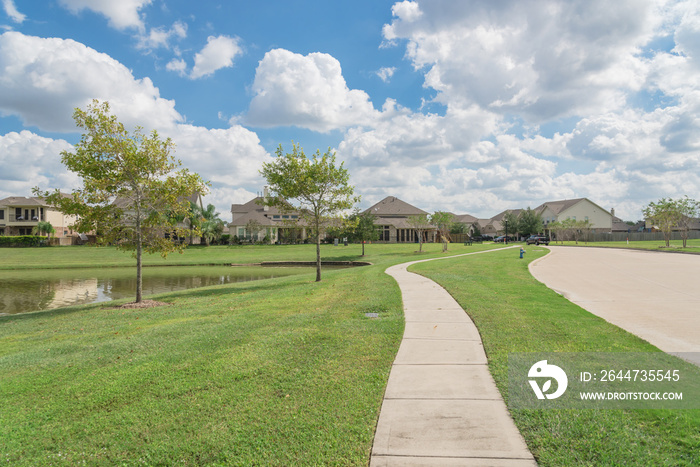 Walking pathway alongside leads to residential houses by the lake in Pearland, Texas, USA.