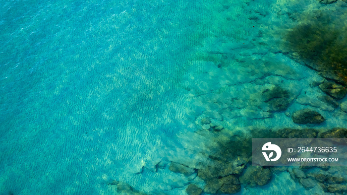 aerial view of the clear blue waters overlooking the underwater rocks and coral against the beautiful natural beach. and the magic of tropical waves and paradise beaches in the Andaman Sea.