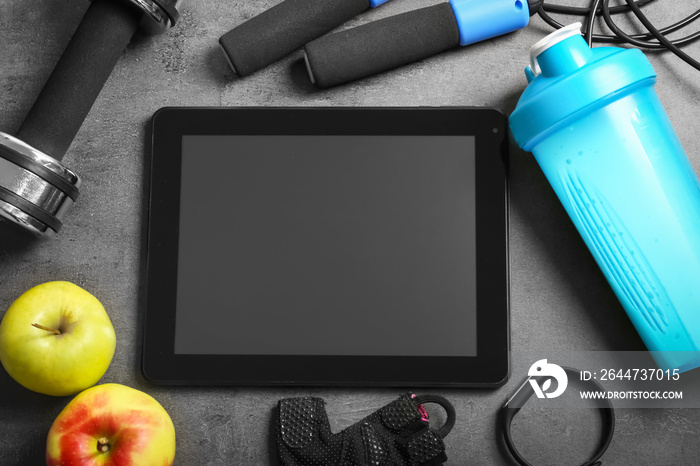 Gym stuff and tablet with blank space for exercise plan on grey background. Flat lay composition