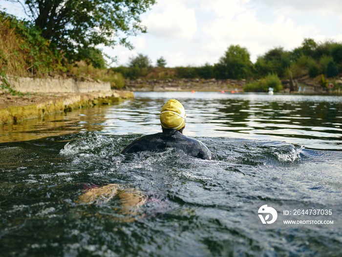 Woman in swimming cap swimming in river