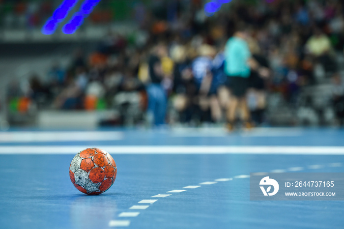 Match ball lying on the parquet near 9 m line.