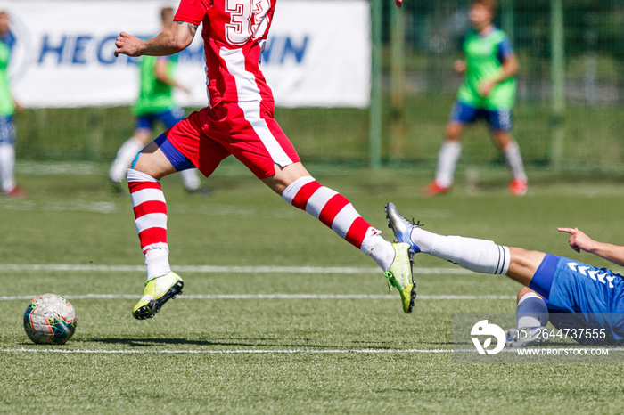 Men play football on the pitch. Two football teams playing soccer