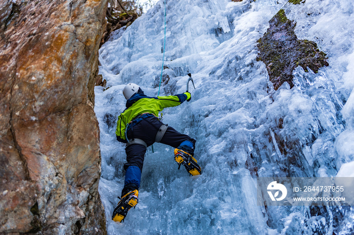 Ice Climbing Man with an Ice Axe and Crampons on a Frozen Waterfall in the Taschachschlucht (Taschach Valley) in the Pitztal in Austria