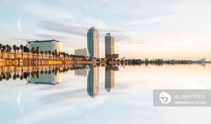 Amazing reflection of the famous tower of Barcelona, Hotel Arts and Mapfre Tower, in front of the beach during a sunny day in Barcelona, Spain.