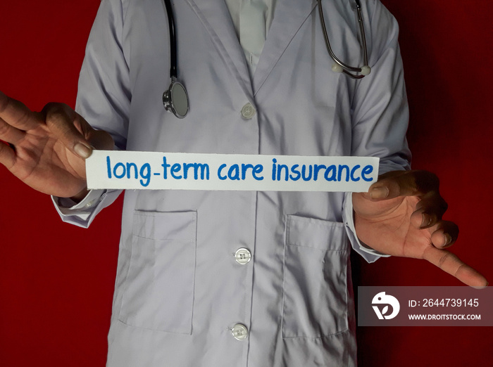 A doctor standing, Hold the long-term care insurance paper text on red background. Medical and healthcare concept.