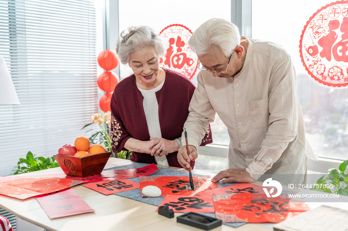 快乐的老年夫妻在家写毛笔字