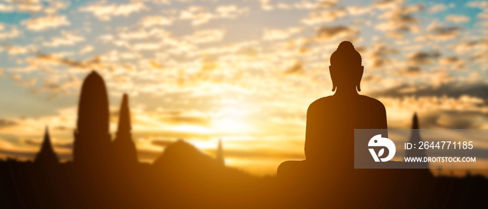 Silhouette of Buddha on golden temple sunset background. Travel attraction in Thailand.