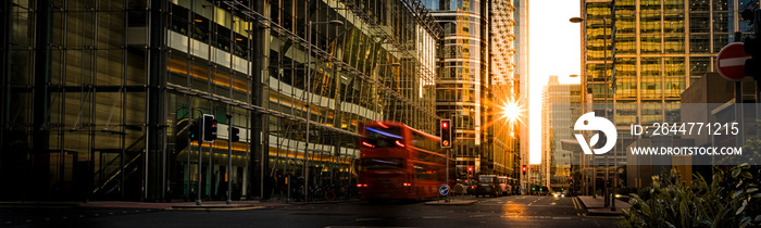 Busy London high street surrounded by large modern office buildings at sunset, England