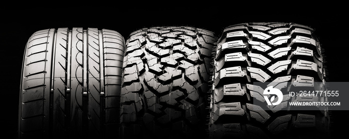 mud all-season all terrain tires and road wheel on a black background.