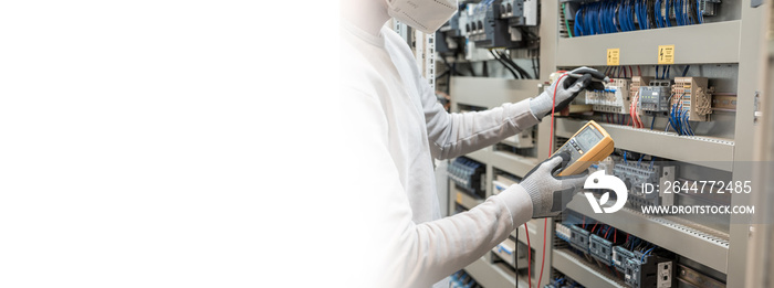 Electricians hands testing current electric in control panel