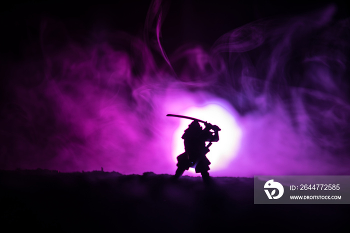 Fighter with a sword silhouette a sky ninja. Samurai on top of mountain with dark toned foggy background.