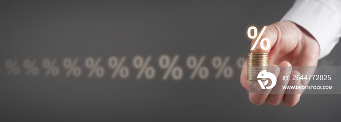 Male hand showing Percentage symbols and coins. Interest rates