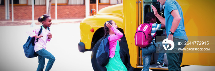 Teacher giving high five to kids while entering in bus