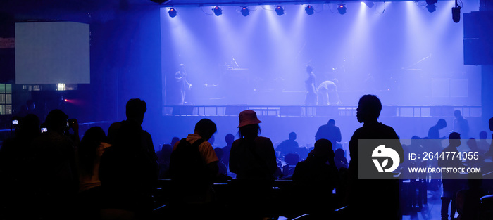 Preparing to perform on stage in low light with a large audience waiting