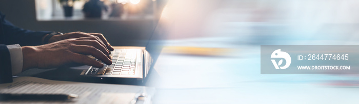 Businessman working on laptop keyboard. Panoramic business banner with copy space.