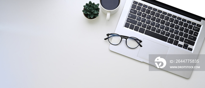 Horizontal photo of computer laptop, glasses, coffee cup and copy space on white background.