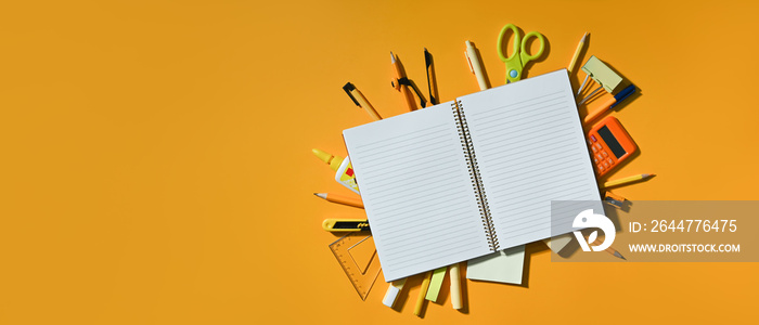 Top view empty notebook and school supplies on yellow background with copy space ready for your design