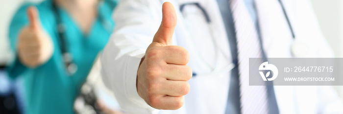 Two doctors show thumb up gesture with hands