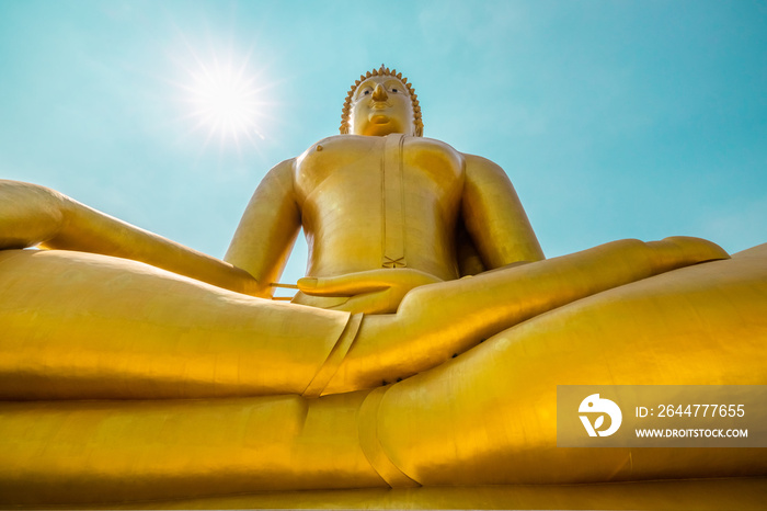 big golden Buddha statue and blue sky over the sun light background