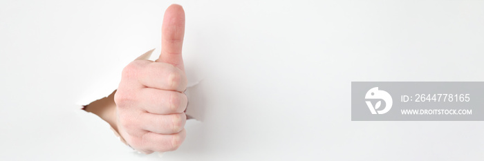 Female hand makes thumbs up gesture closeup