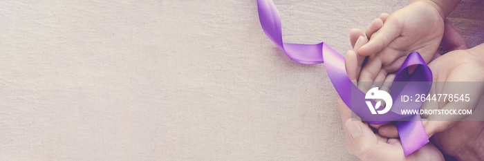 Adult and child hands holding purple ribbons, Alzheimer’s disease, Pancreatic cancer, Epilepsy awareness, world cancer day on purple background