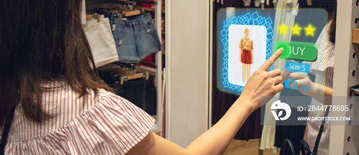 iot smart retail futuristic technology concept, happy girl try to use smart display with virtual or augmented reality  in the shop or retail to choose select ,buy cloths and give a rating of products