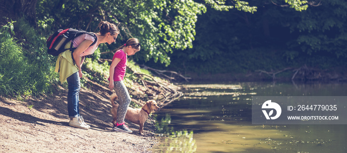 Mother and daughter with dog by the lake