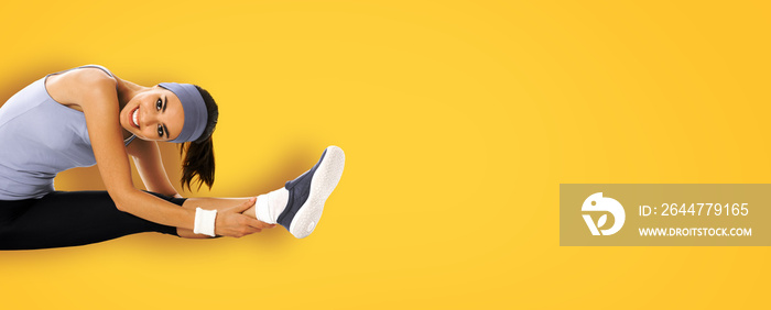 Happy smiling african american woman in sportswear doing fit stretching exercise or youga moves, isolated over yellow background. Young sporty model at studio. Health, beauty and fitness concept.