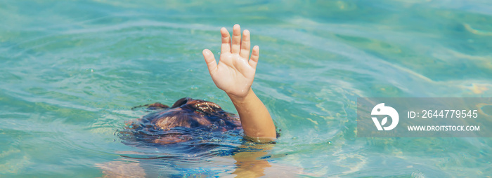 kid is drowning in the sea. Selective focus.