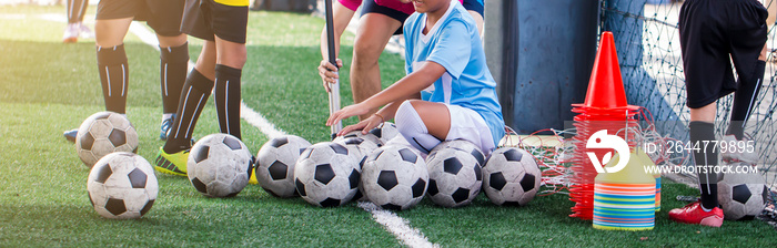 id soccer player and coach are pump air in to a football.