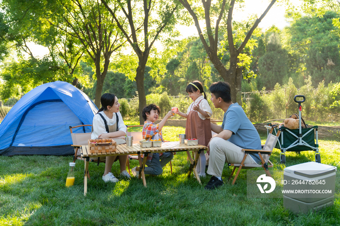 一家四口在露营地野餐开心干杯庆祝
