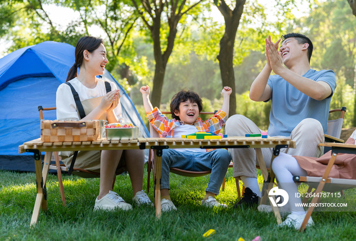 一家四口在露营地玩游戏开心欢呼庆祝