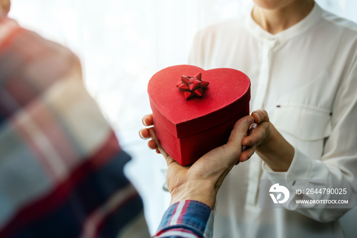 valentines day. man giving romantic heart gift box to his woman. couple in love