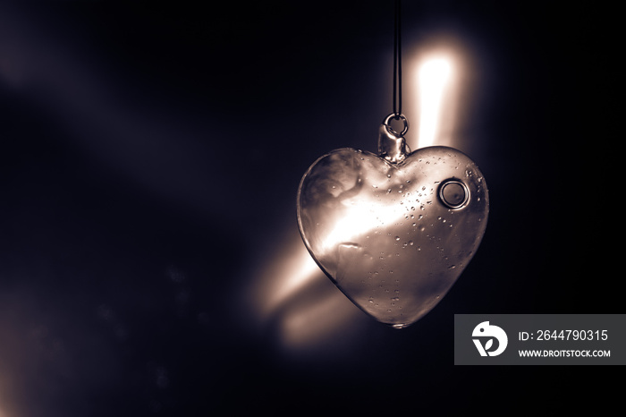 Valentines Day Concept. Glass transparent heart on dark. Crystal heart in the dark, glass heart glow