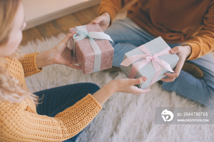 Closeup of a couple exchanging christmas presents, gifts