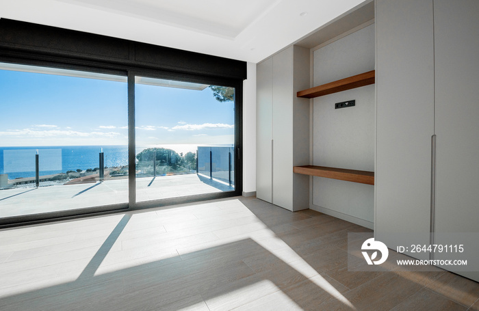 Empty rooms in a new house with large windows overlooking the sea. Automatic blinds. Glass partition