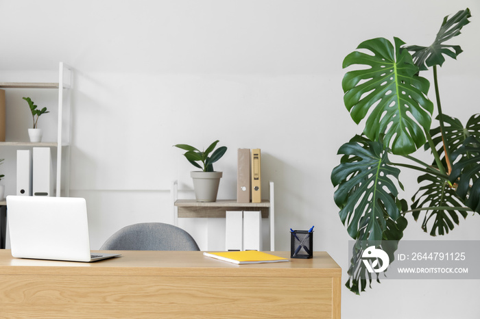 Wooden desk with laptop in interior of modern office