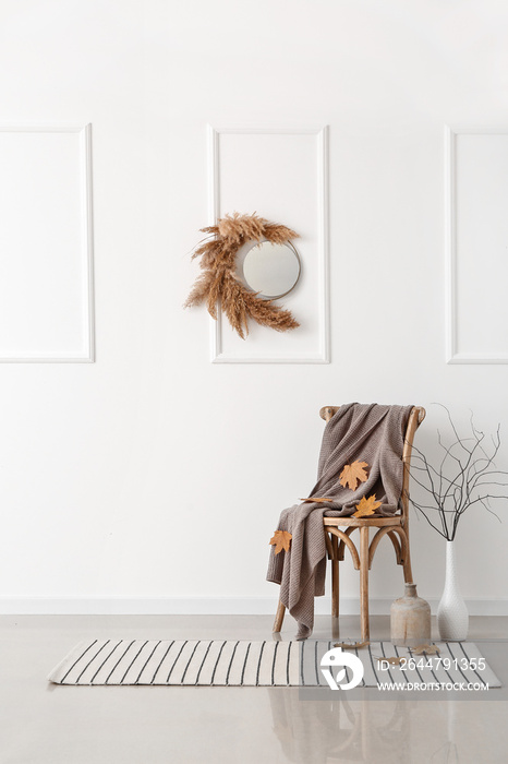 Chair and beautiful autumn decor in interior of light room