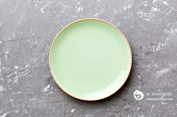 Top view of empty green plate on cement background. Empty space for your design