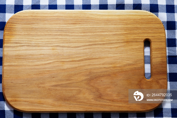 empty wooden cutting board on tablecloth close-up