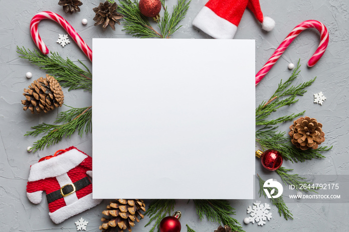 Flat lay Christmas composition. square Paper blank, pine tree branches, christmas decorations on Col