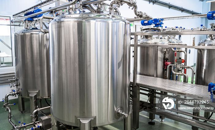 Dairy production. Apparatus for bottling milk products. Steel tanks at milk factory.