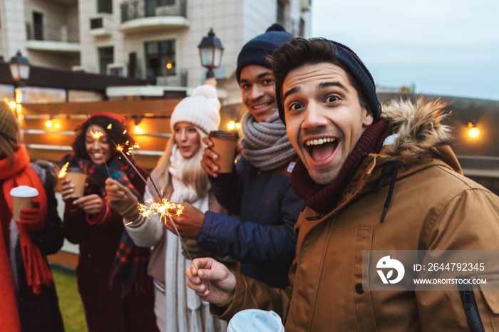 Happy young friends talking with each other drinking coffee outdoors winter concept take a selfie by